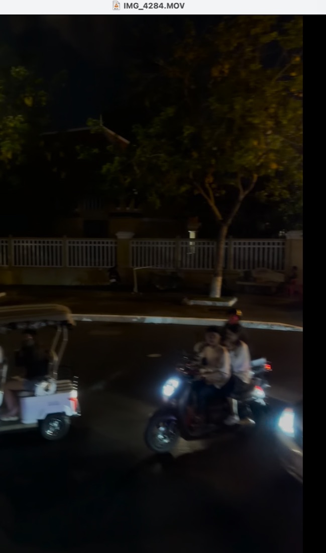 A family riding through a Cambodian street at night